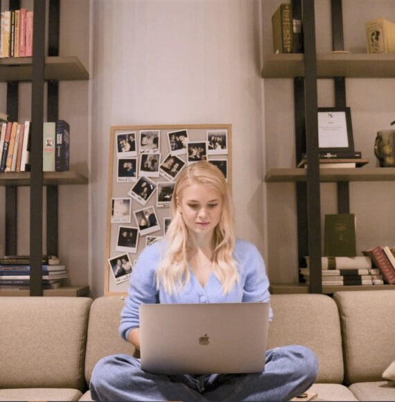 Girl sitting in her student apartment with a laptop